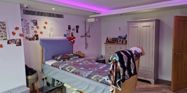Photo of adapted bedroom with mobility bed and ceiling track hoists.