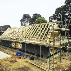Image of an accessible annexe under construction on site in Kent. Wood framed building with scaffold.