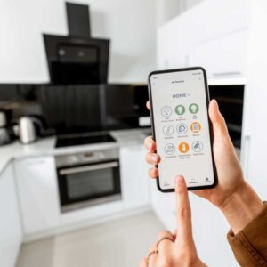 Image of a SmartHome technology app on a smartphone being used in an accessible kitchen.